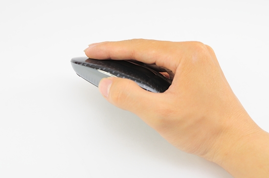 a hand holding onto a computer mouse that is black