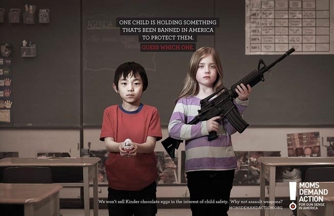 a girl holding an aka rifle next to a little boy