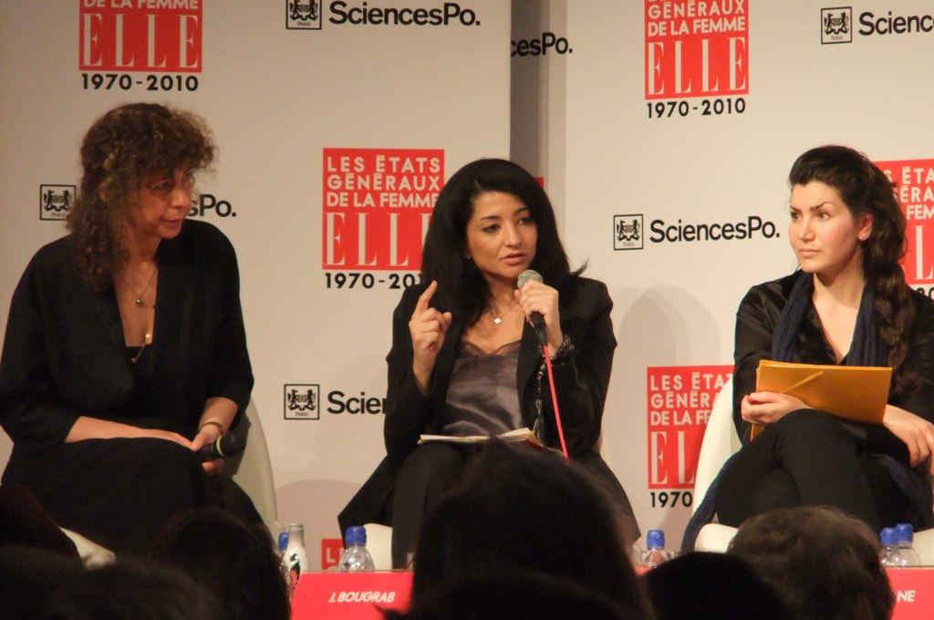 three women are talking while sitting in front of an audience