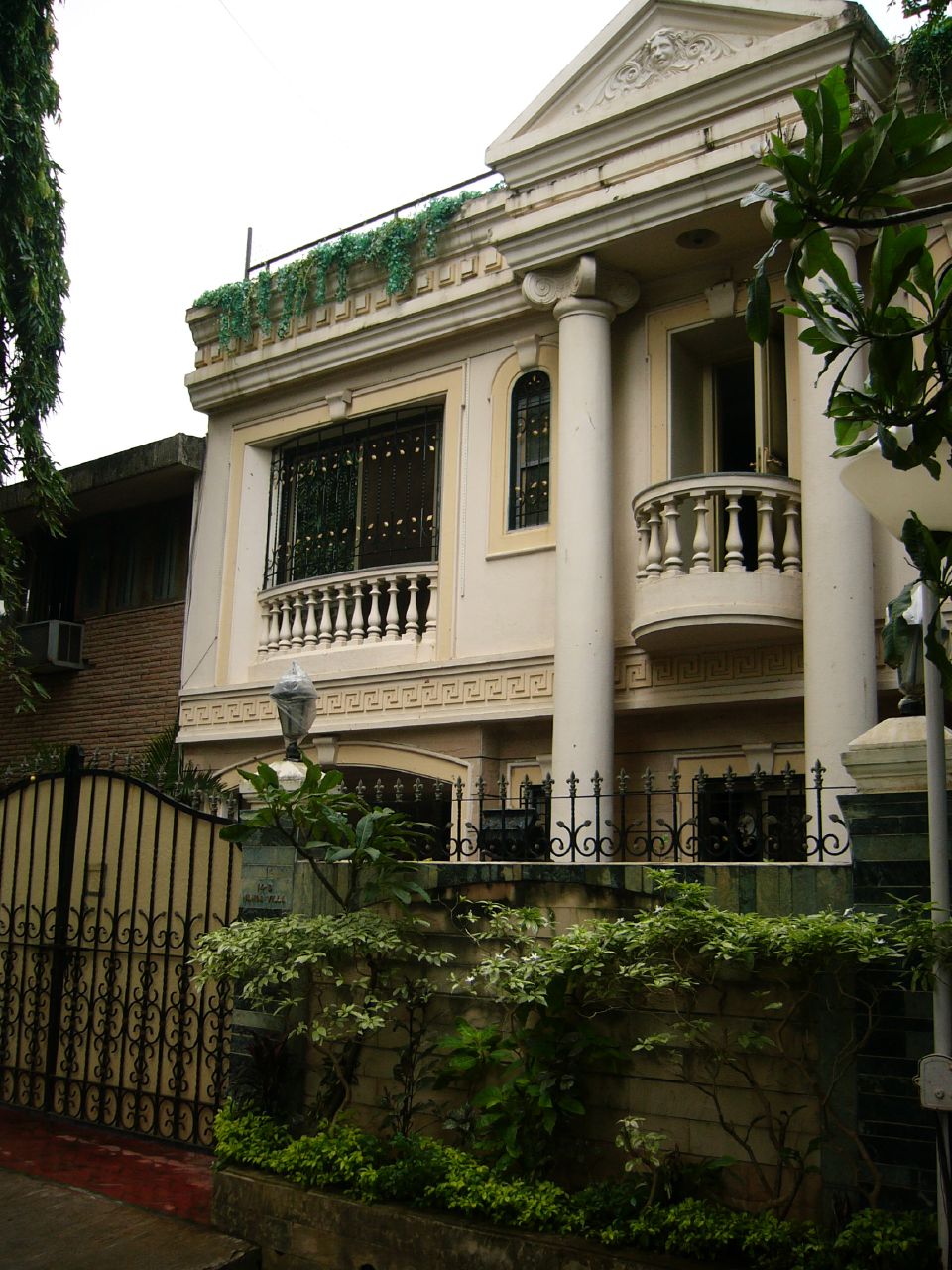 a white building surrounded by lush green foliage