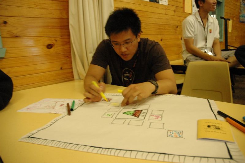 two men sitting at a table working on paper