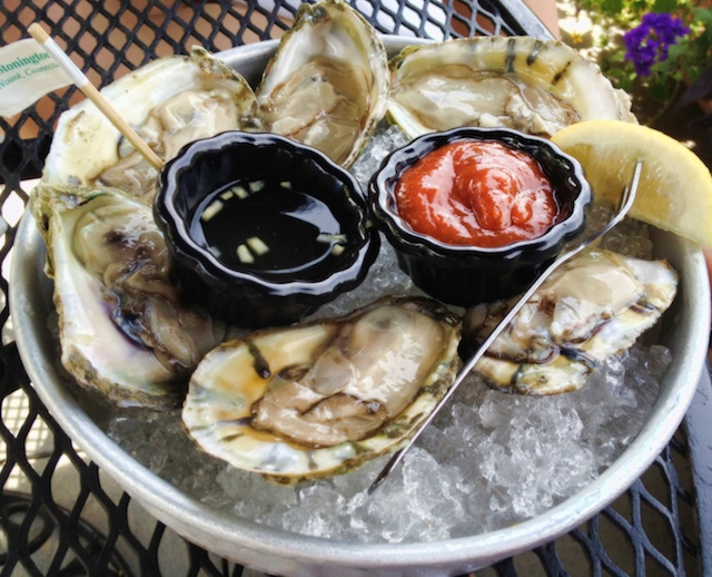 oysters with dipping sauce on an ice platter