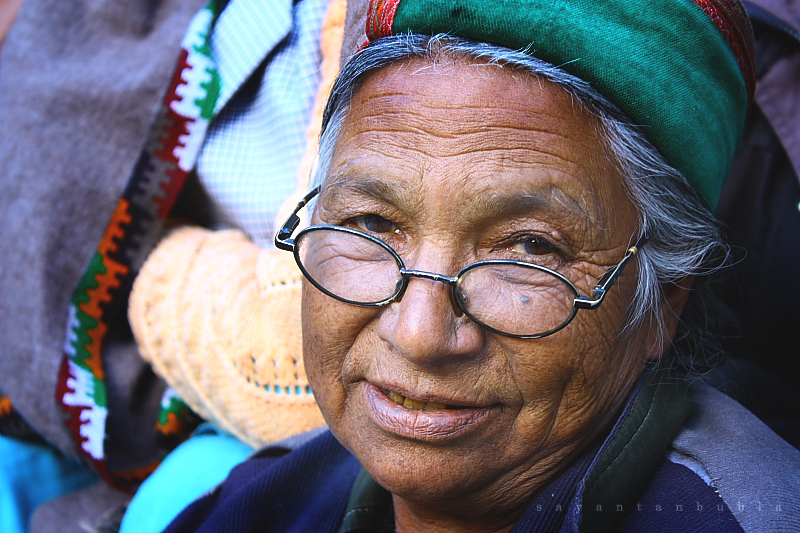 a woman with glasses and a green scarf on her head