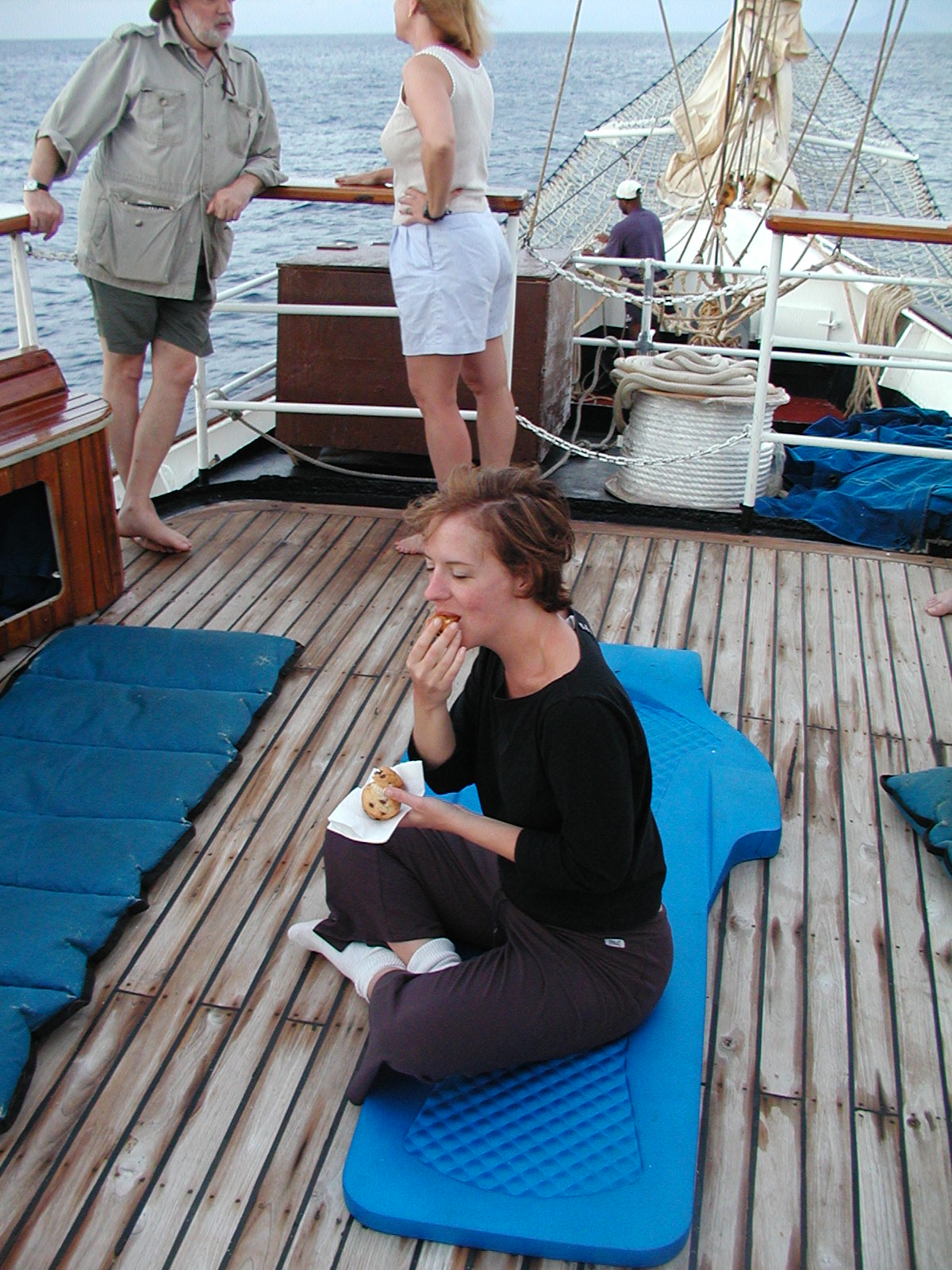 the woman eats on a mat on the deck