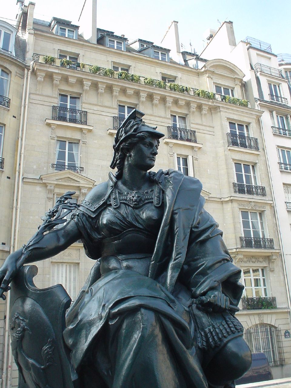 a statue of a woman is next to some tall buildings