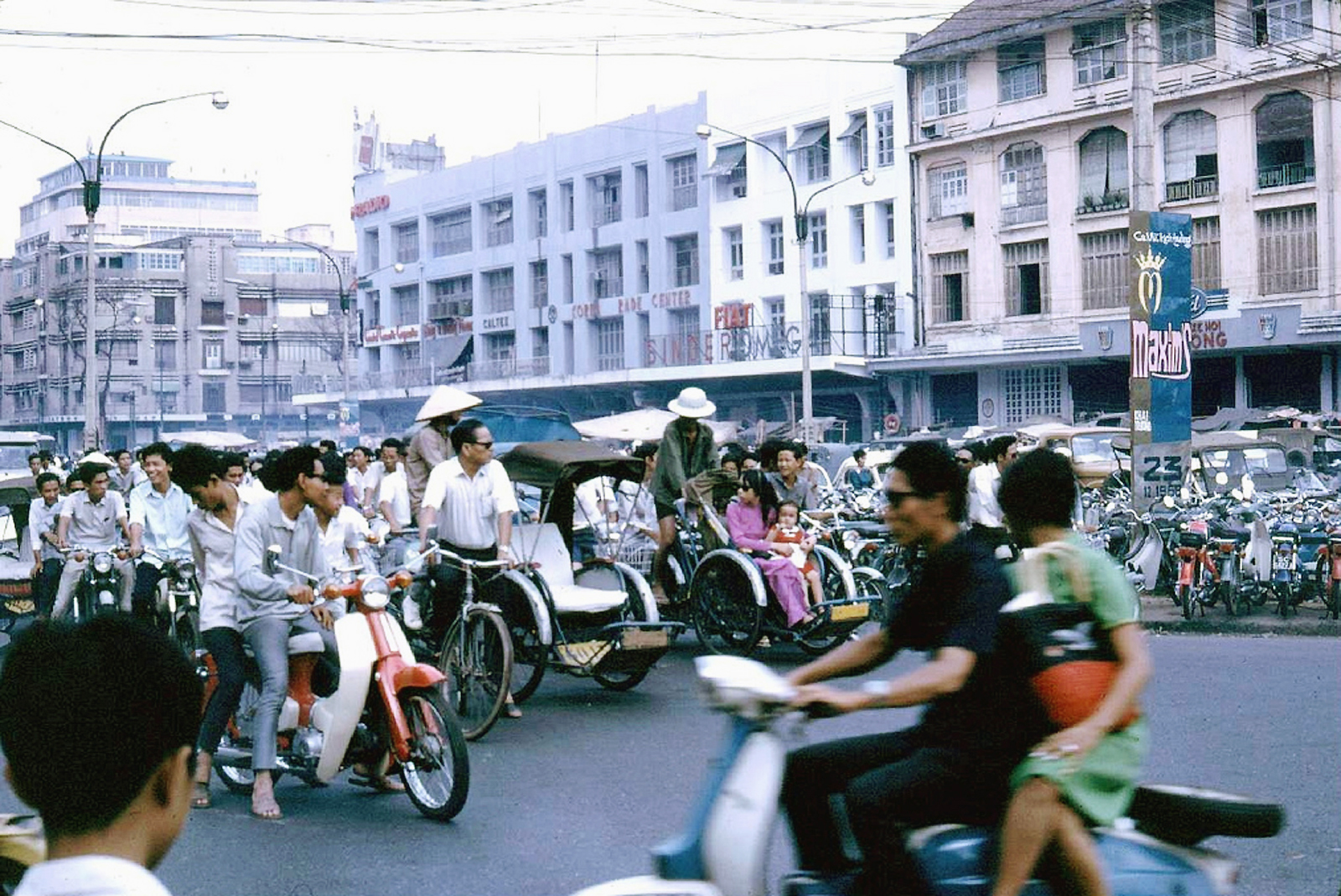 several people riding motor bikes on a crowded street