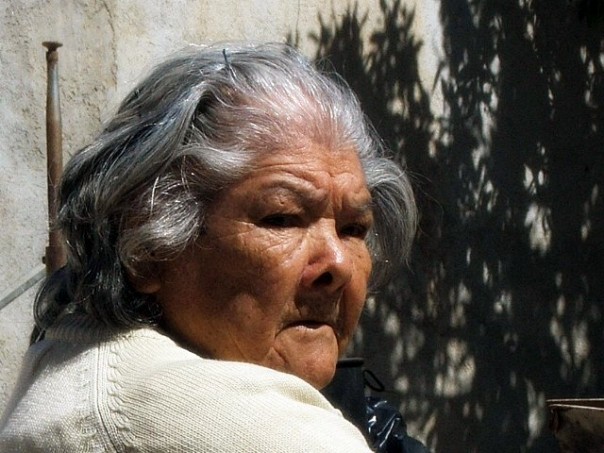 an old woman standing with her head looking off to the side