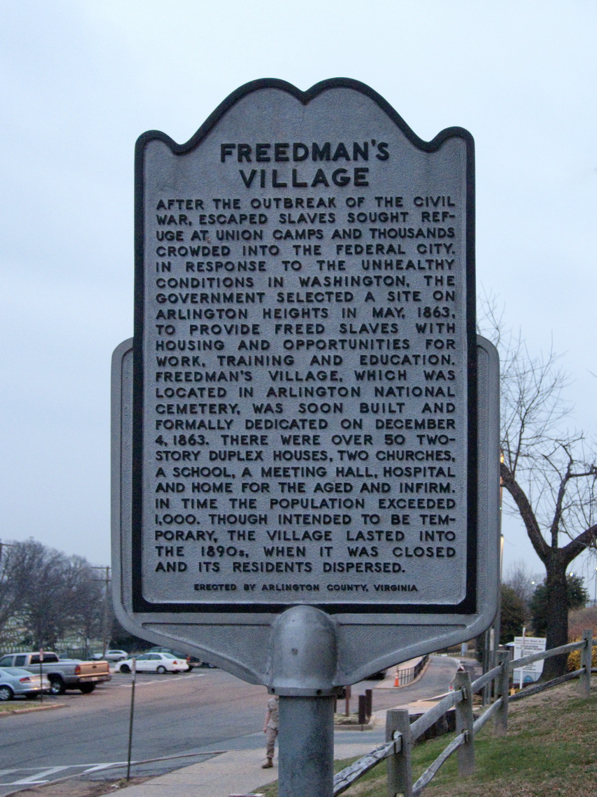 a historical marker about a village that is located next to a street