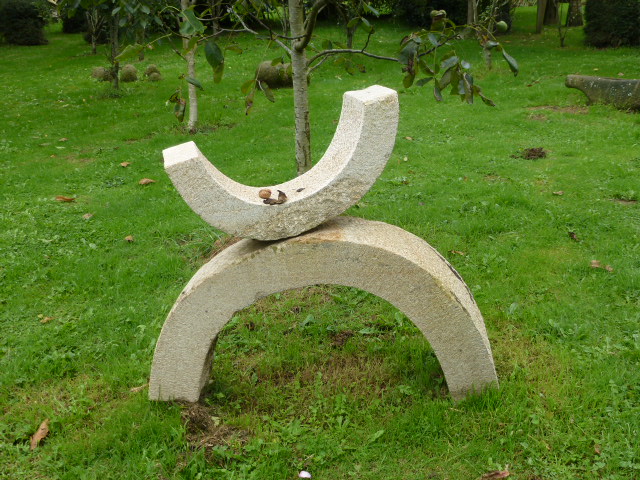 an outdoor sculpture that is sitting on some grass