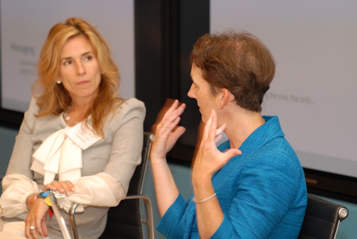 a woman with her hand to the chest speaks to another woman
