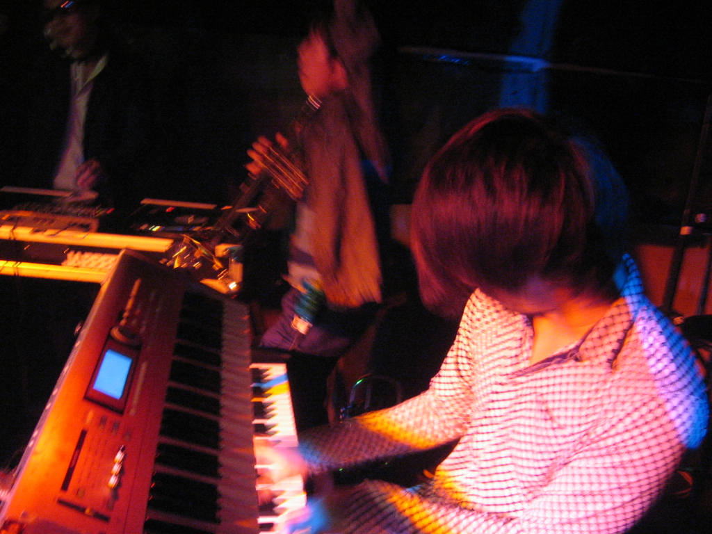 a woman is playing a piano in a room