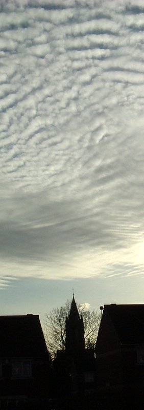 a cloudy sky with clouds above a building