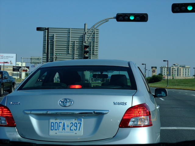 the rear view of a car that is stopped at an intersection