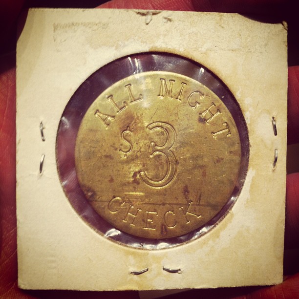 a gold coin is held in hand, with a smaller piece of paper around it