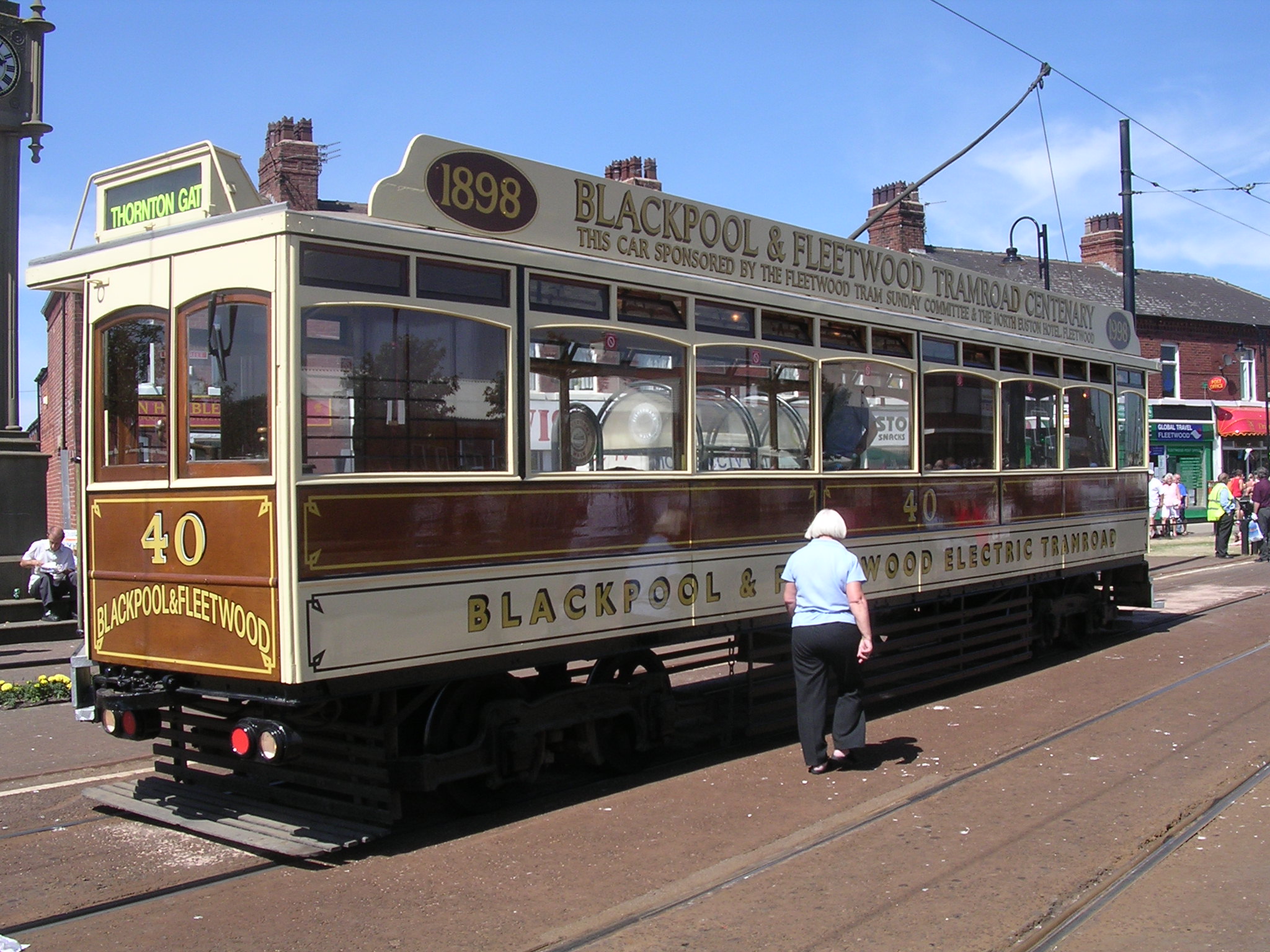 an antique streetcar car is parked next to a red truck