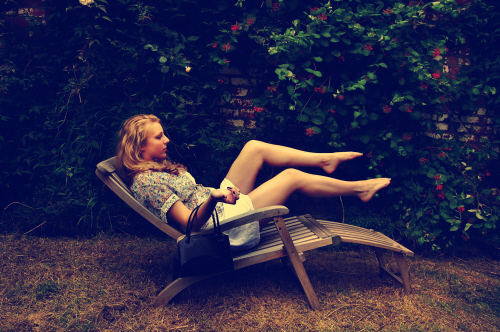 a woman sitting in a chair with her legs up