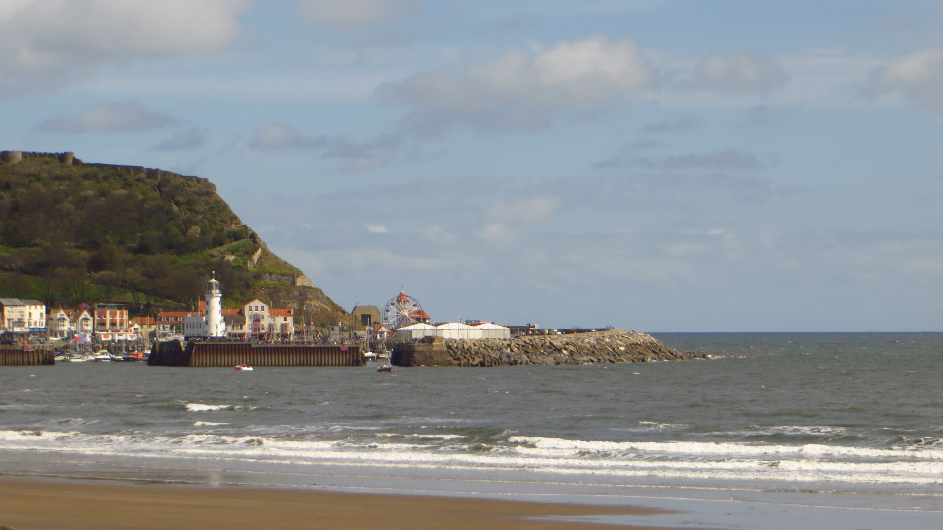 an island is seen in the distance as a surfer rides on the beach