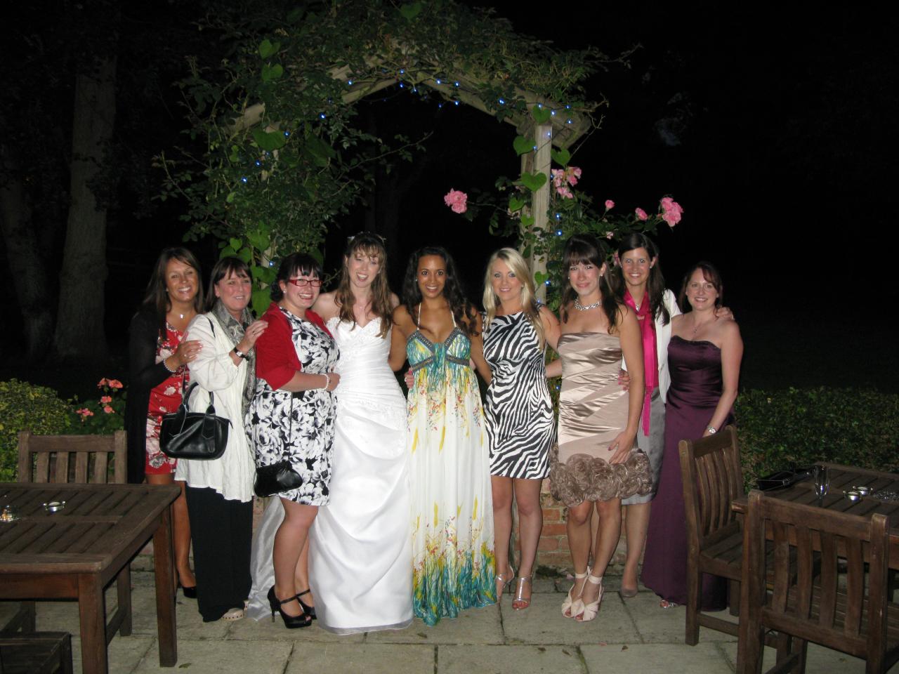 several beautiful women posing in formal clothes at night