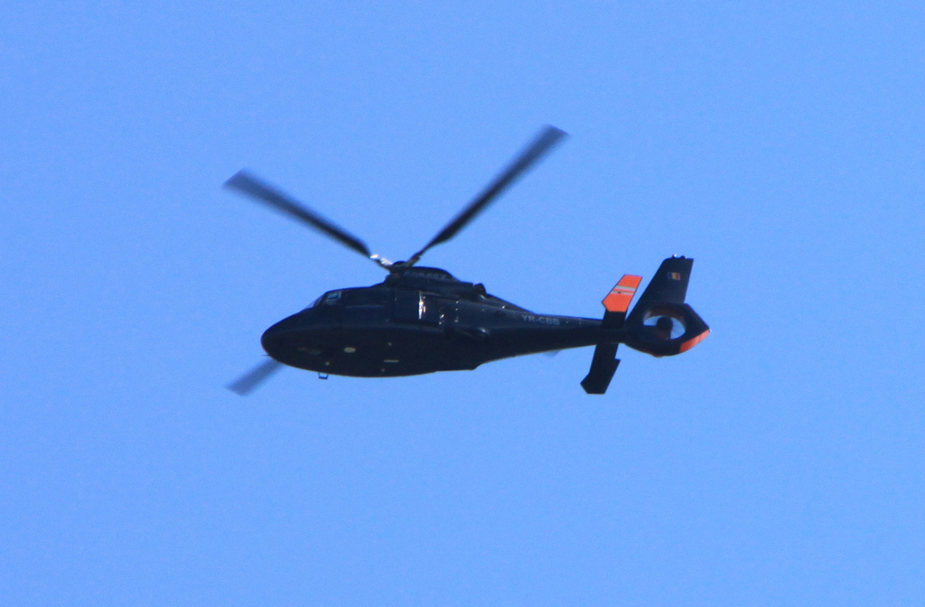 a helicopter flying in the air on a clear day