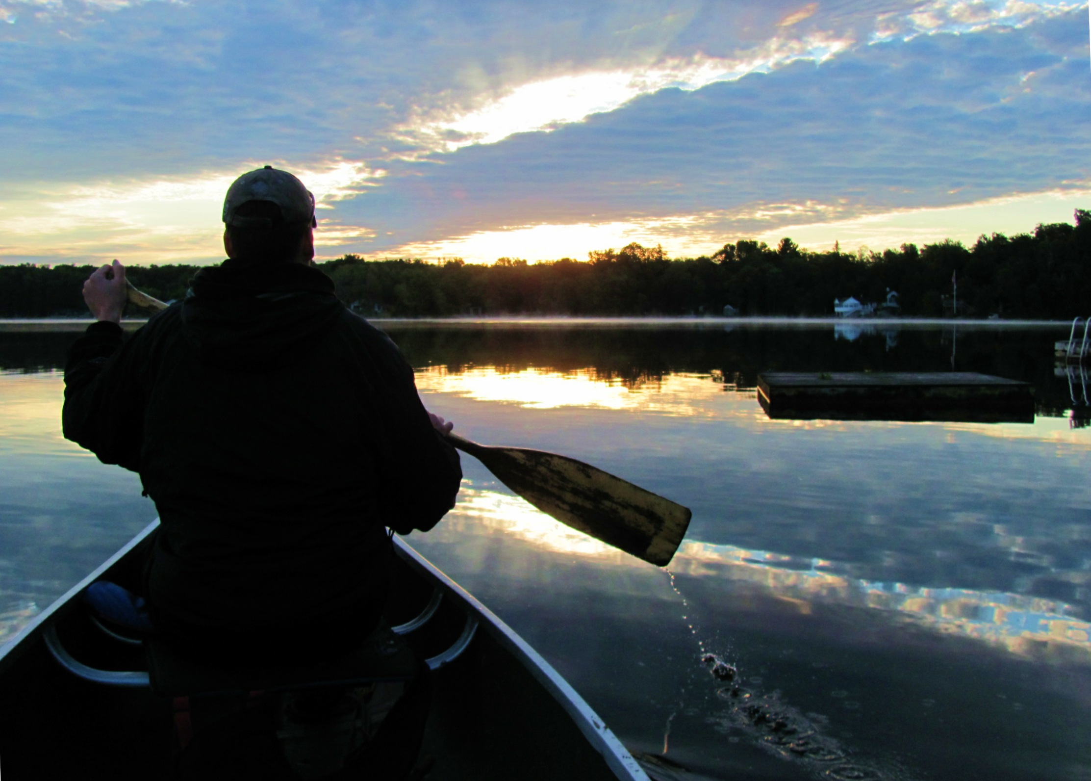 a man in the canoe paddling away on a sunny day