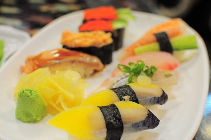 a white plate filled with different types of sushi