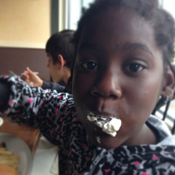 an african american girl eats some food off of her plate