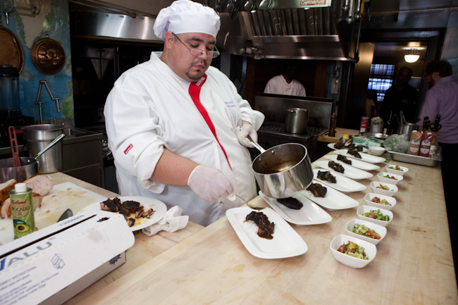 a cook in uniform prepares various dishes on serving platters