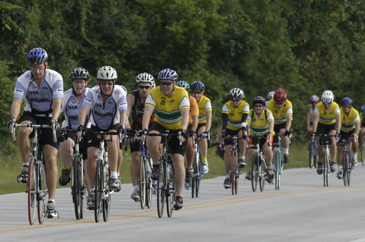 many people are riding bicycles down a road