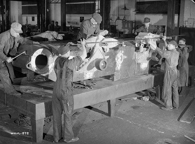 a group of men standing next to each other in a factory