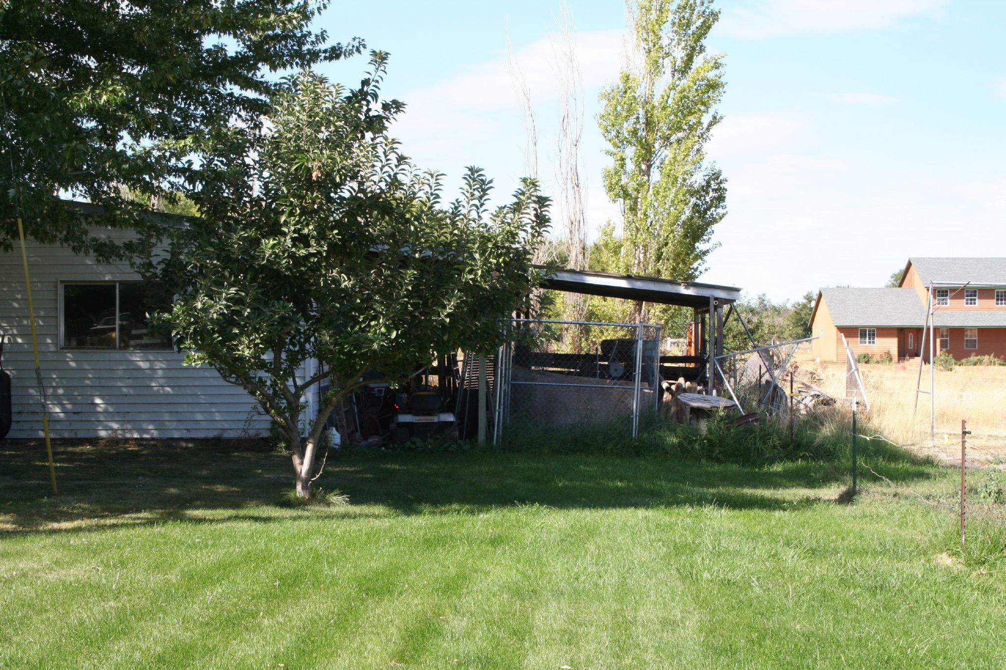 an empty backyard in the evening hours of a sunny day