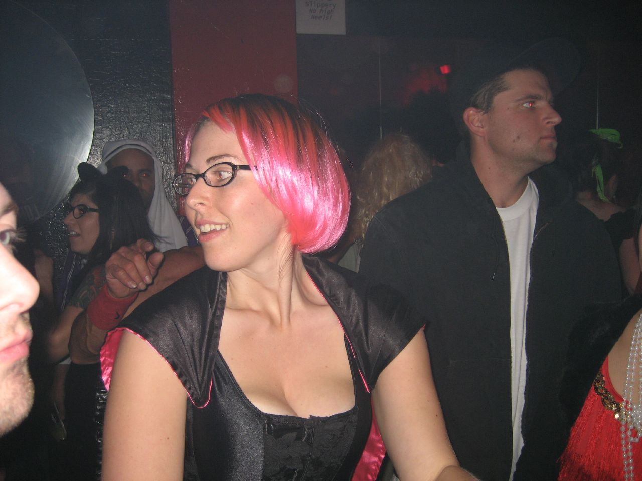 a girl with pink hair is sitting at a party