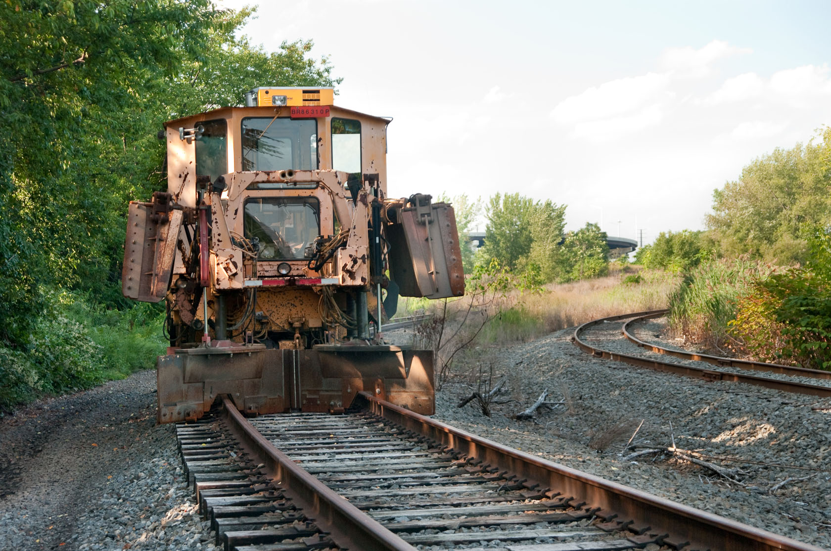 an old truck sits on tracks near some trees