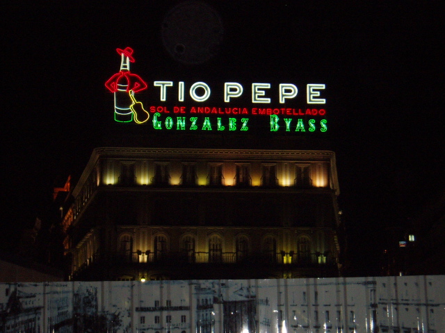 a lighted building with christmas decorations below and toppe lit