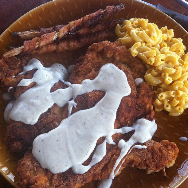 fried pork, macaroni and cheese with gravy on a plate