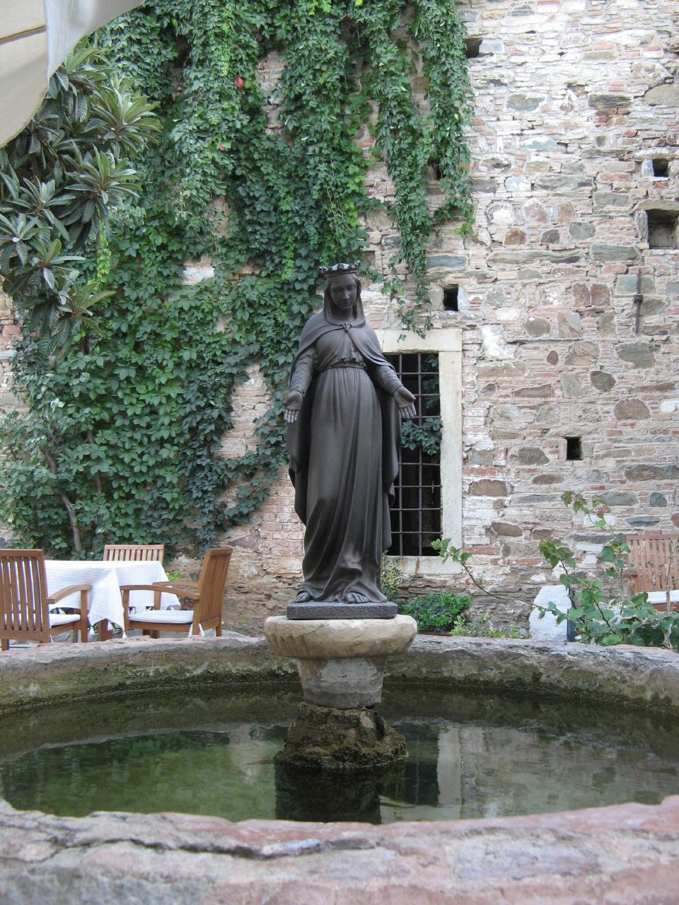 a statue is standing in front of a small fountain