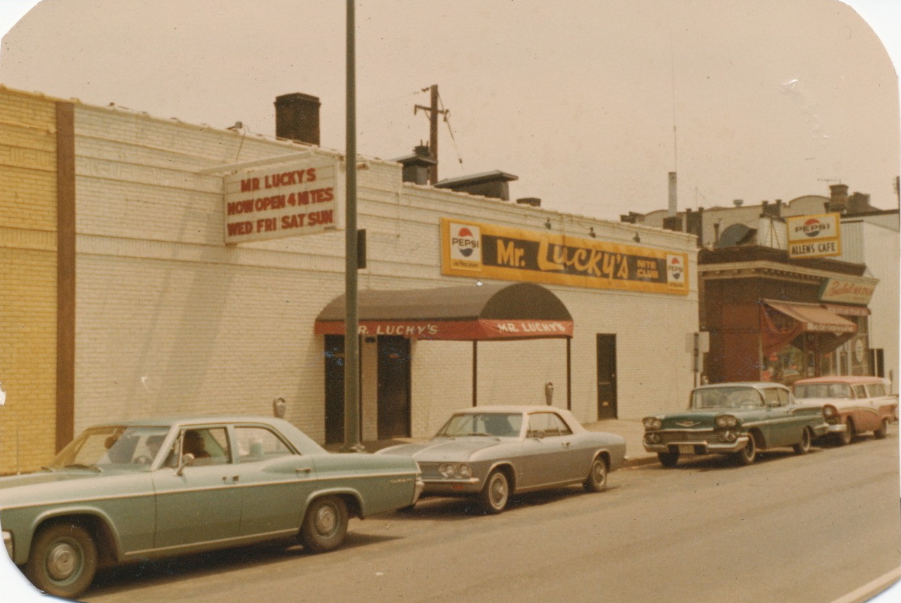 cars lined up outside a grocery store in front of a building