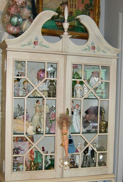 a china cabinet with several pieces in a room