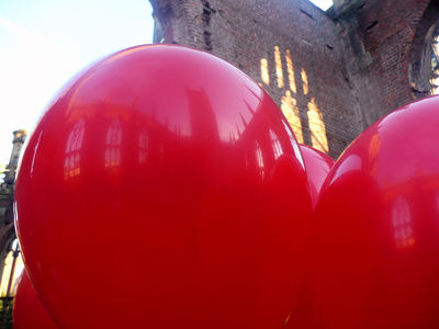 large red balloons near the wall of a building