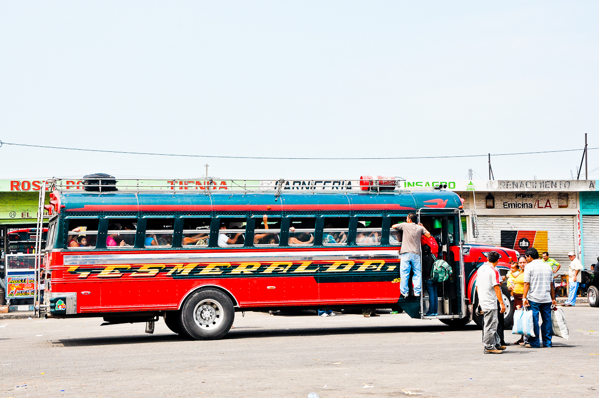 a group of people getting onto a bus in the day time