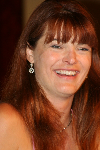 a woman with red hair smiles for the camera