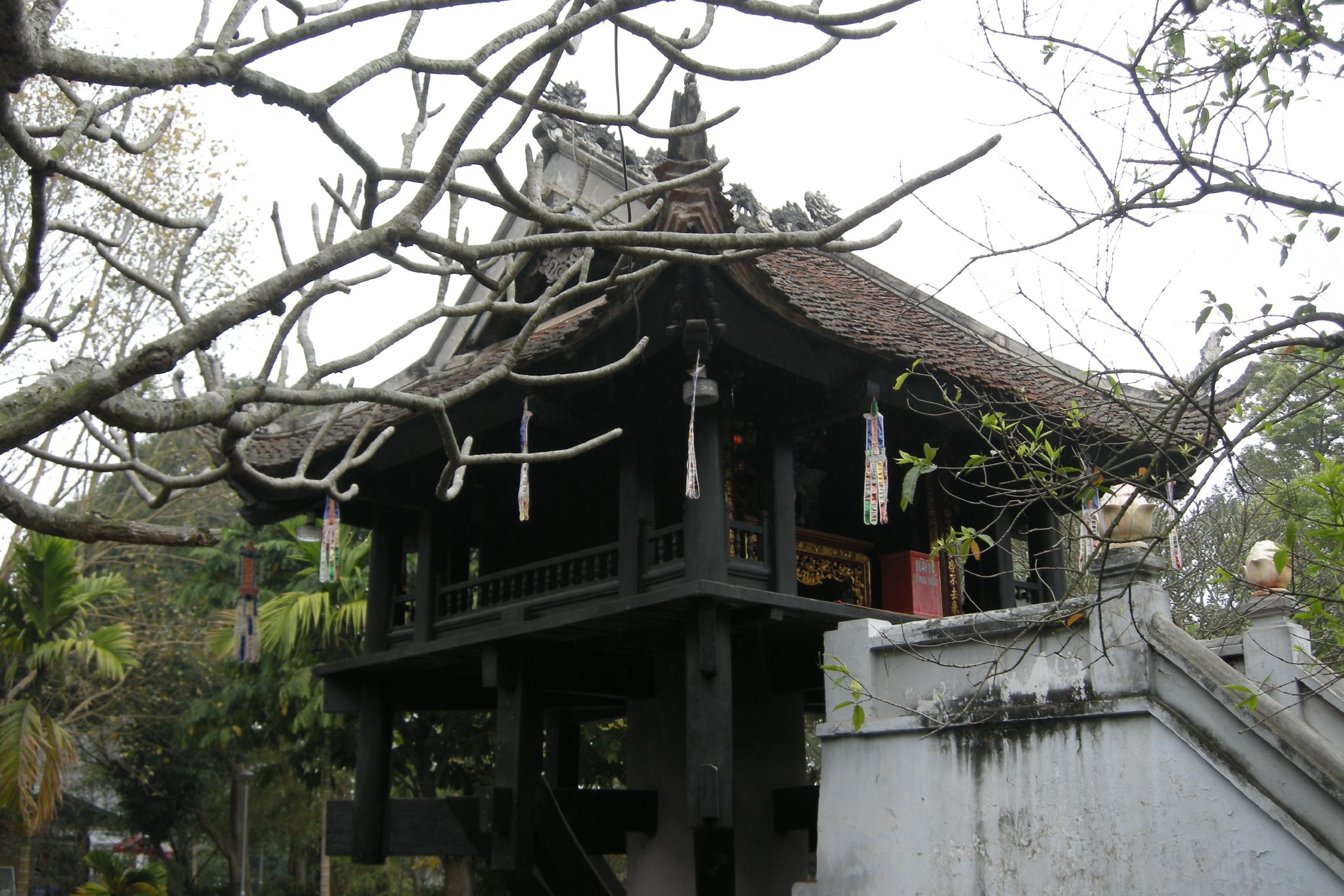 a pagoda house stands amongst trees in the background