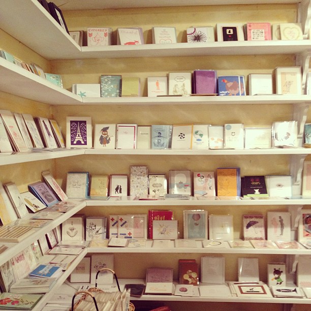 there is a store with greeting cards in white shelves