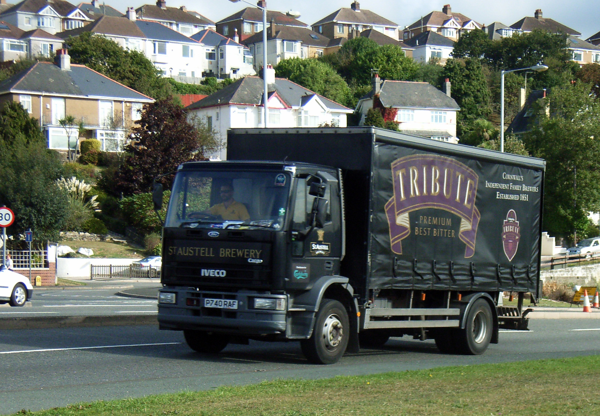 a large black truck traveling down a road