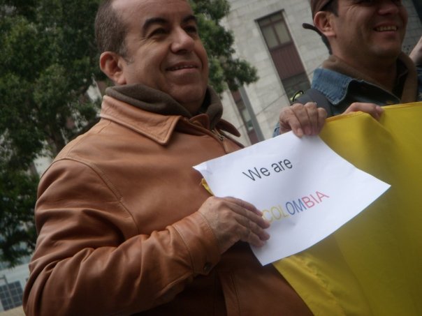 a man holding a sign while standing next to another man