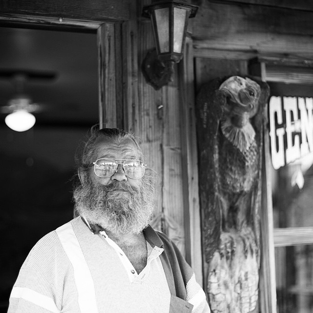 a black and white po of an old man in front of a store