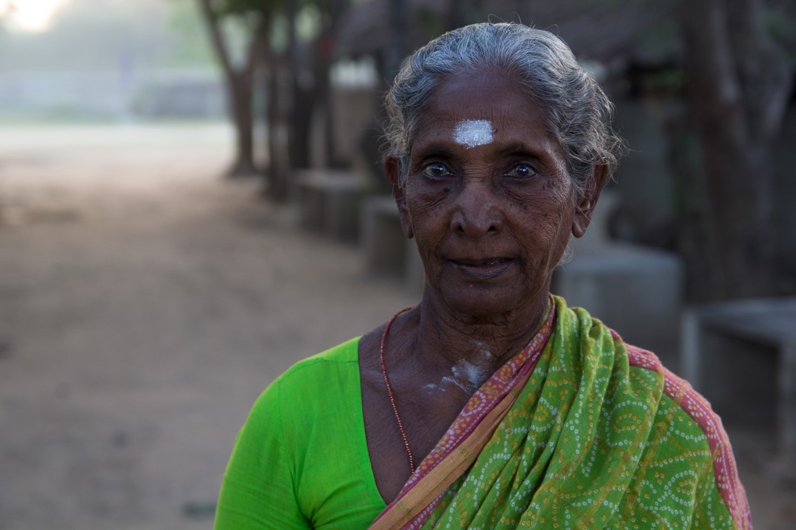 an old lady standing with her face painted yellow