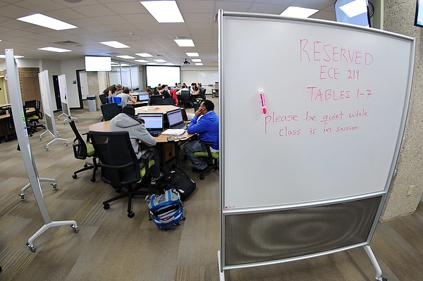 some students are sitting at desks with a white board