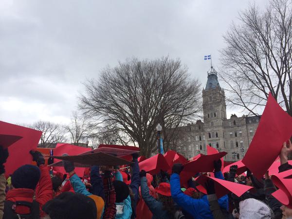 people in the park holding up red umbrellas