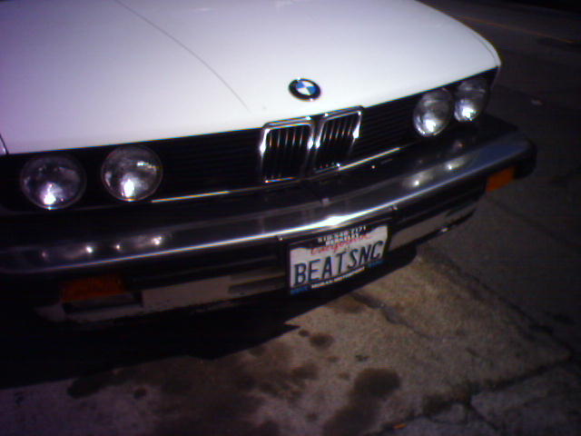 a white bmw parked on the side of a street