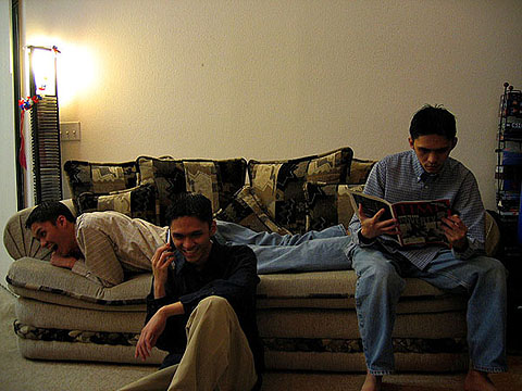 a group of people sitting on couches reading paper